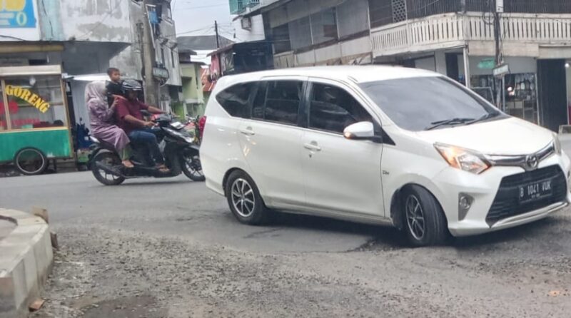 Kenderan melewati jalan berlubang di depan tokoh masyarakat Diamond Kota Blangpidie. Foto. Dok. Teukunizar/noa.co.id
