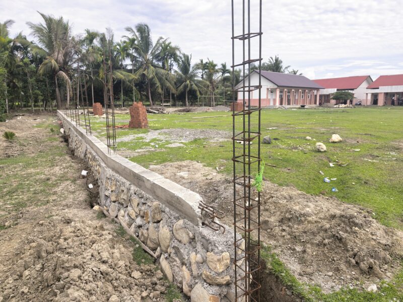 Kondisi pagar SMP Negeri 4 Muara Tiga, tidak dikerjakan lagi dan tanpa papan informasi proyek, (Foto.Amir Sagita.NOA.co.id).