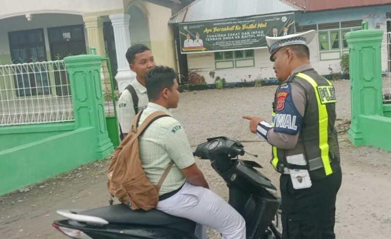 Personel Satlantas Polres Abdya menegur pelajar yang tidak menggunakan helm saat berkendara. Foto. Dok. Teukunizar/noa.co.id