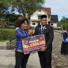 Sekda Aceh Jaya, H. Masri, menyerahkan bonus kepada pelatih taekwondo Aceh Jaya atas prestasi yang diraih dalam ajang Internasional Kesatria Nusantara PBTI Series Championship 2026, di halaman Kantor Bupati Aceh Jaya, Rabu (28/10/2026). Foto: Dok. Pemkab Aceh Jaya
