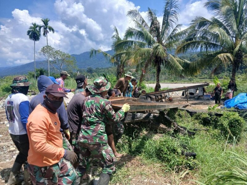 Babinsa Kodim 0108/Aceh Tenggara bersama pekerja menyiapkan material konstruksi untuk pembangunan Jembatan Gantung Perintis di Desa Deleng Damar, Kamis (15/10/2026). Foto: Dok. Istimewa 